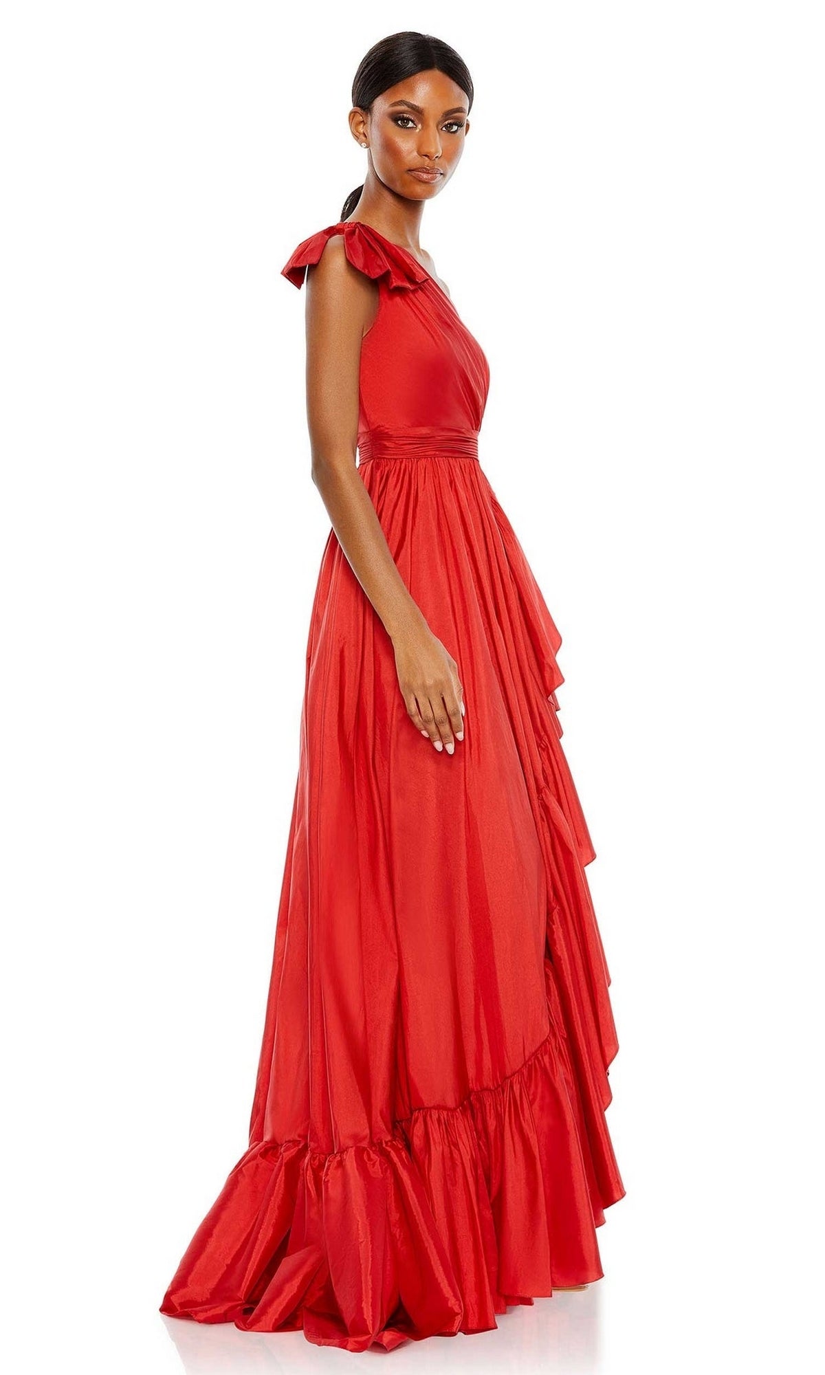 A woman poses in the Long Formal Dress 68027 by Mac Duggal, a sleeveless, floor-length red gown with draped detailing and a ruffled hem, facing slightly to the side against a plain white background.